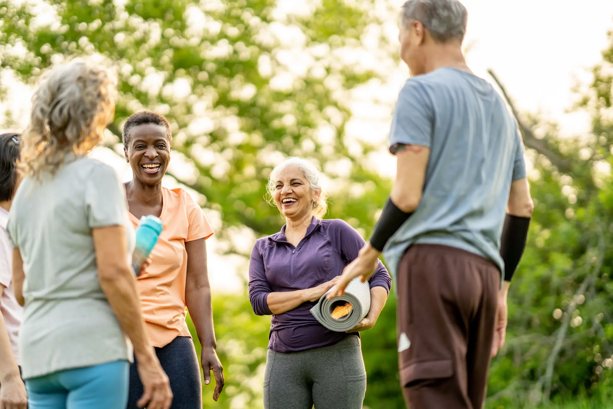 Group of friends enjoying an outdoor exercise session with resistance bands.