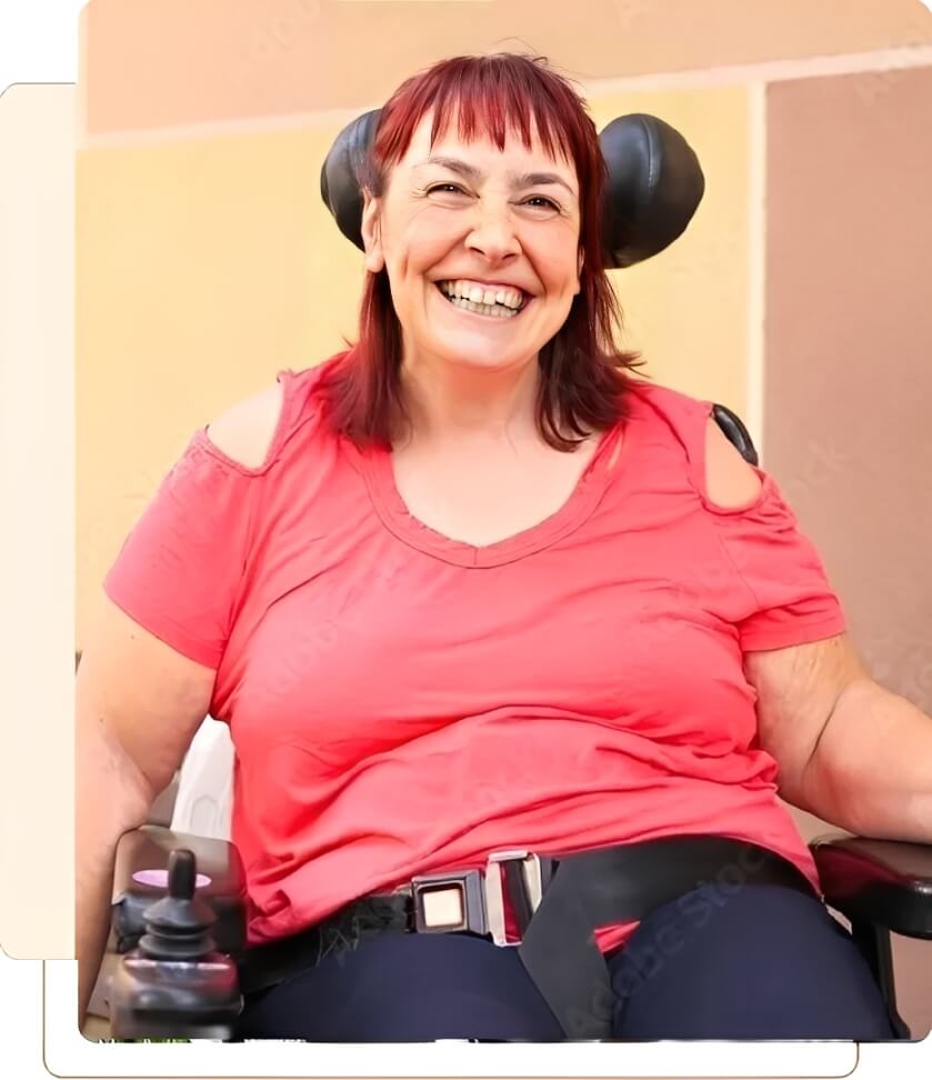 Smiling woman in wheelchair wearing red shirt.